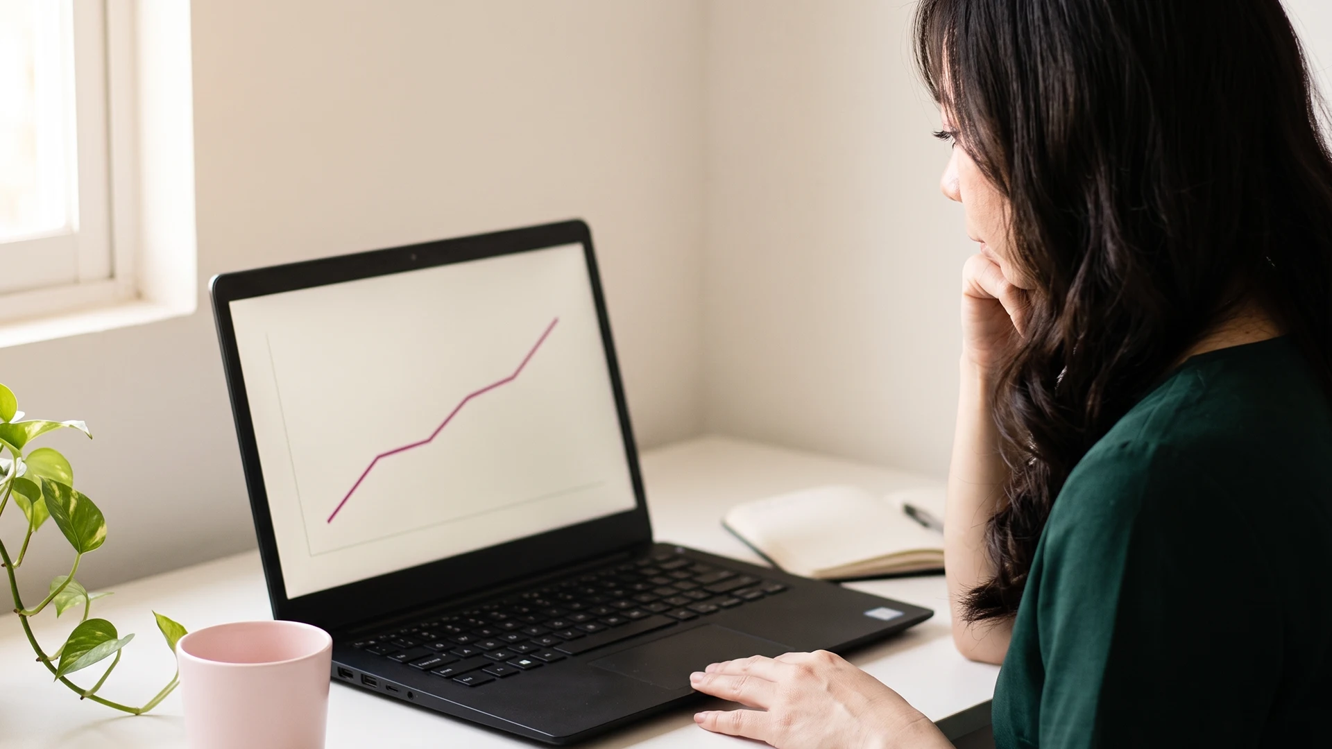 Shopify store owner at a desk reviewing the Search Console generative AI report on a laptop