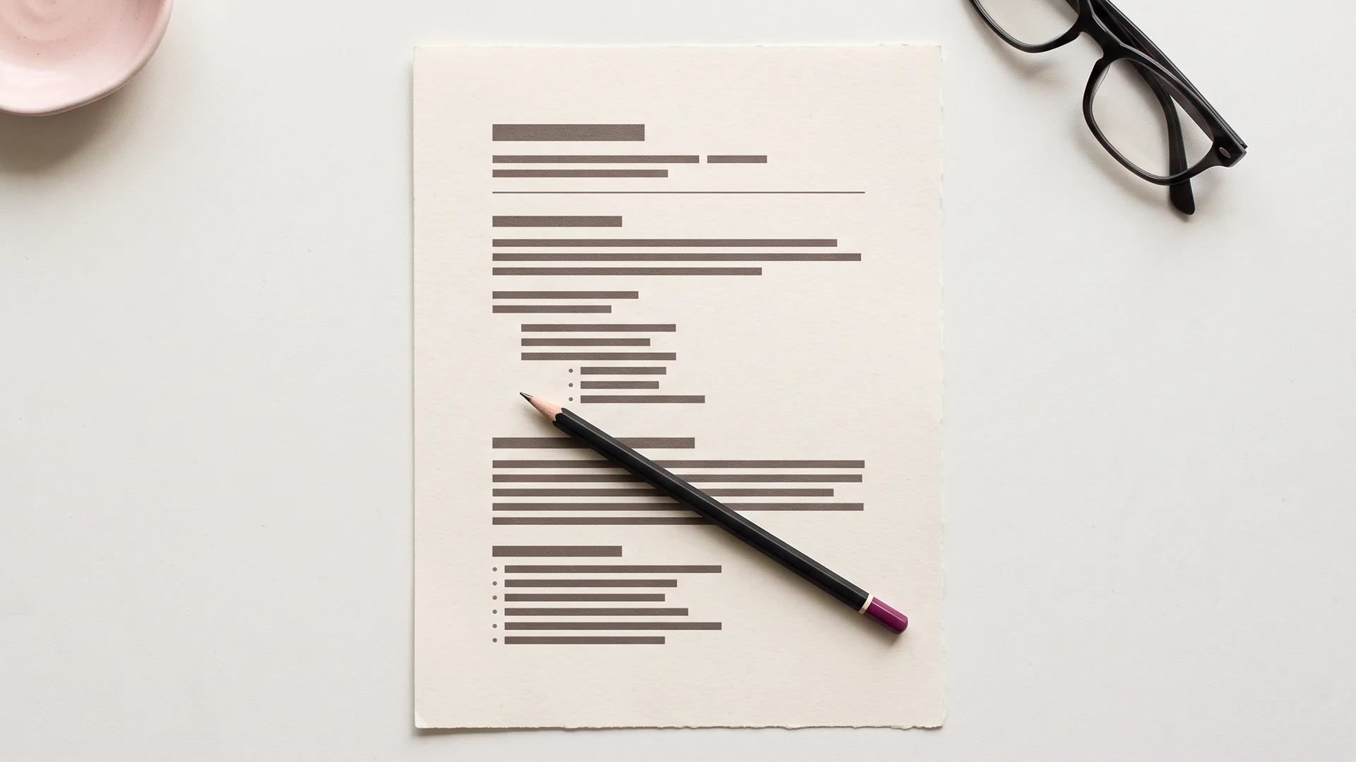Printed blog post template outline on a light desk with a pencil resting across it