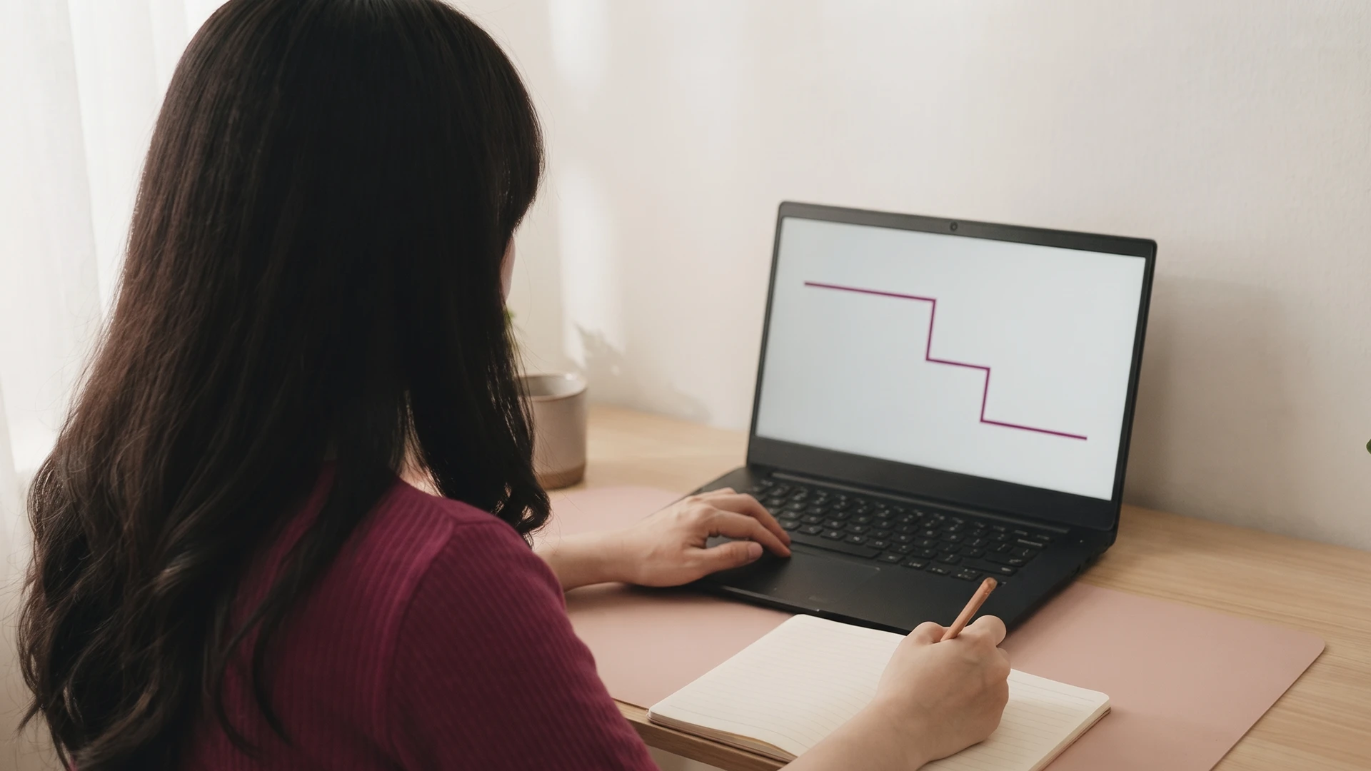 Shop owner at a laptop reviewing a chart where Shopify sessions dropped in a single step